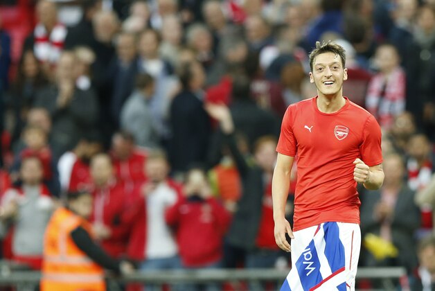 Arsenal's Mesut Ozil celebrates after the end of the English FA Cup semifinal soccer match between Arsenal and Reading at Wembley stadium in London, Saturday, April 18, 2015.  Arsenal won the game 2-1 after extra time .(AP Photo/Alastair Grant)