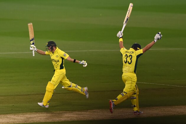 Australia's Shane Watson, right, and Steve Smith raise their bats and take the final run for their seven wicket win over New Zealand in the Cricket World Cup final in Melbourne, Australia, Sunday, March 29, 2015. (AP Photo/Andy Brownbill)