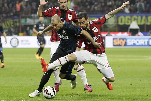 Inter Milan's Rodrigo Palacio, center, challenges for the ball with AC Milan's Suso, right, and AC Milan's Andrea Poli during the Serie A soccer match between Inter Milan and AC Milan at the San Siro stadium in Milan, Italy, Sunday, April 19, 2015. (AP Photo/Antonio Calanni)