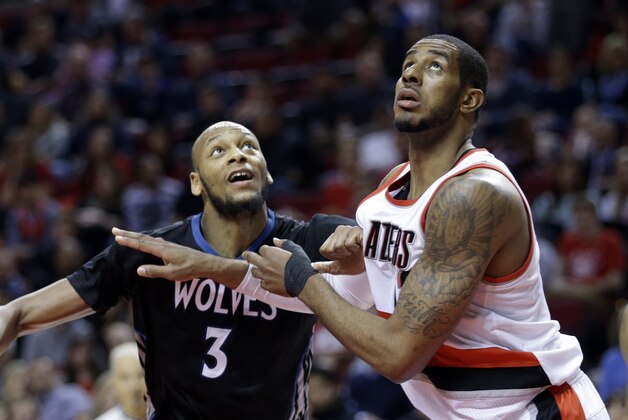 Portland Trail Blazers forward LaMarcus Aldridge, right, jockeys for rebound position with Minnesota Timberwolves forward Adreian Payne during the second half of an NBA basketball game in Portland, Ore., Wednesday, April 8, 2015.  (AP Photo/Don Ryan)