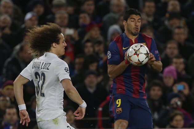 Barcelona's Luis Suarez, right, uses his hands to control the ball as PSG's David Luiz tries to stop him during a Group F Champions League soccer match between FC Barcelona and PSG at the Camp Nou stadium in Barcelona, Spain, Wednesday Dec. 10, 2014. (AP Photo/Emilio Morenatti)