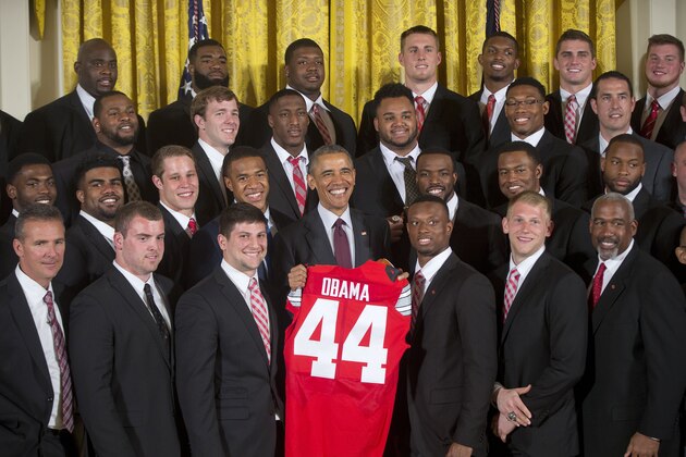 President Barack Obama is presented with a Ohio State football jersey by Ohio State football players as he welcomed the NCAA College Football Playoff National Champion Ohio State Buckeyes, Monday, April 20, 2015, during a ceremony in the East Room of the White House in Washington. Buckeyes Coach Urban Meyer is at left. (AP Photo/Pablo Martinez Monsivais)