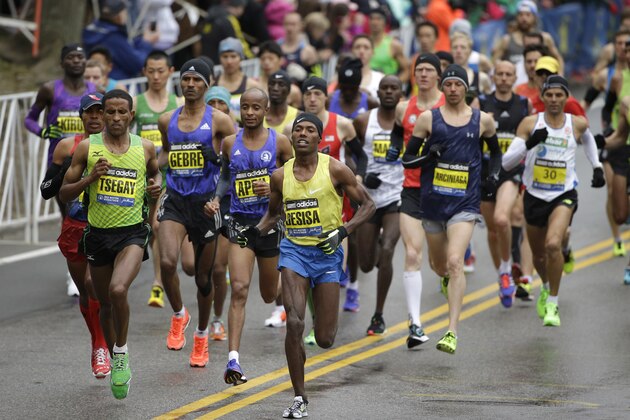 Lelisa Desisa, of Ethiopia, center, runs with the pack through Hopkinton, Mass., en route to a win in the Boston Marathon, Monday, April 20, 2015. (AP Photo/Steven Senne)