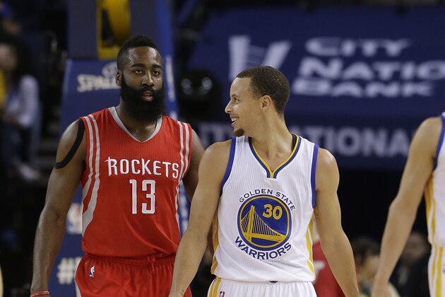 Golden State Warriors guard Stephen Curry (30) smiles next to Houston Rockets guard James Harden (13) during the first half of an NBA basketball game in Oakland, Calif., Wednesday, Jan. 21, 2015. (AP Photo/Jeff Chiu)