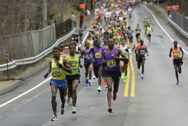 Lelisa Desisa, of Ethiopia, left, leads the pack through Hopkinton, Mass., en route to a win in the Boston Marathon, Monday, April 20, 2015. (AP Photo/Steven Senne)
