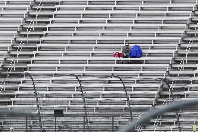 Two fans sit in the rain before a NASCAR Sprint Cup Series auto race at Bristol Motor Speedway on Sunday, April 19, 2015, in Bristol, Tenn. (AP Photo/Wade Payne)