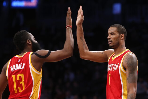 Houston Rockets' James Harden (13) celebrates with teammate Trevor Ariza (1) during the first quarter of an NBA basketball game against the Brooklyn Nets Monday, Jan. 12, 2015, in New York.  Houston beat Brooklyn 113-99. (AP Photo/Jason DeCrow)