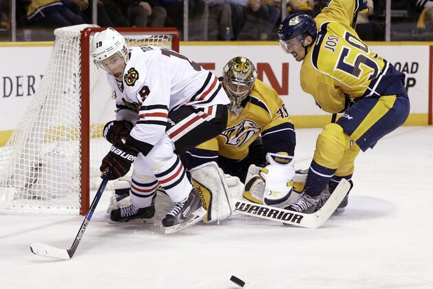 Chicago Blackhawks center Jonathan Toews (19) watches the puck bounce away after charging the net against Nashville Predators goalie Pekka Rinne (35), of Finland, and defenseman Roman Josi (59), of Switzerland, in the first overtime of Game 1 of an NHL Western Conference hockey playoff series Wednesday, April 15, 2015, in Nashville, Tenn. (AP Photo/Mark Humphrey)
