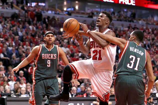 Chicago Bulls guard Jimmy Butler (21) is fouled by Milwaukee Bucks center John Henson (31) as Jared Dudley watches during the second half in Game 2 of the NBA basketball playoffs Monday, April 20, 2015, in Chicago. The Bulls won 91-82. (AP Photo/Charles Rex Arbogast)