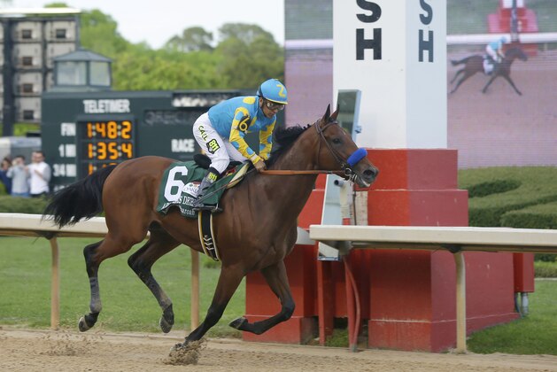 Jockey Victor Espinoza leads American Pharoah to the finish pole to win the $1 million Arkansas Derby horse race at Oaklawn Park in Hot Springs, Ark., Saturday, April 11, 2015. (AP Photo/Danny Johnston)