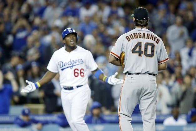 El abridor de los Gigantes de San Francisco, Madison Bumgarner, discute con el cubano Yasiel Puig, de los Dodgers de Los Angeles, quien le conectó un jonrón el viernes 9 de mayo de 2014 (AP Foto/Danny Moloshok)