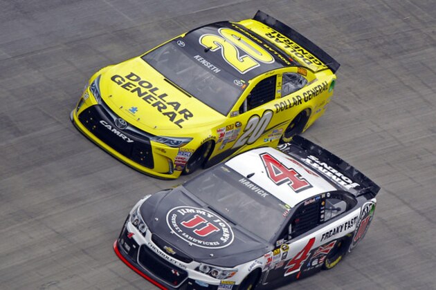 Driver Kevin Harvick (4) passes Matt Kenseth (20) to take the lead during a NASCAR Sprint Cup Series auto race at Bristol Motor Speedway on Sunday, April 19, 2015, in Bristol, Tenn. The race was stopped due to rain. (AP Photo/Wade Payne)