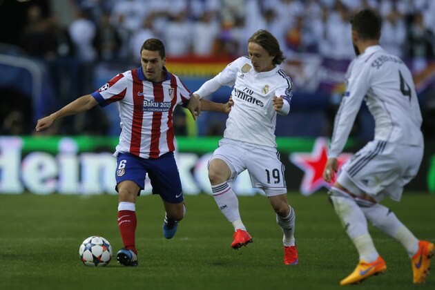 Atletico's Koke fights for the ball against Real Madrid's Luka Modric next to Sergio Ramos, right, during the Champions League quarterfinal first leg soccer match between Atletico Madrid and Real Madrid at the Vicente Calderon stadium in Madrid, Spain, Tuesday, April 14, 2015. (AP Photo/Andres Kudacki)