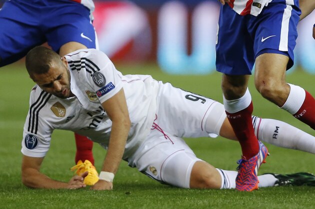 Atletico's players challenge Real Madrid's Real Madrid's Karim Benzema, down, during the Champions League quarterfinal, first leg soccer match between Atletico de Madrid and Real Madrid at the Vicente Calderon stadium in Madrid, Spain, Tuesday, April 14, 2015. (AP Photo/Daniel Ochoa de Olza)