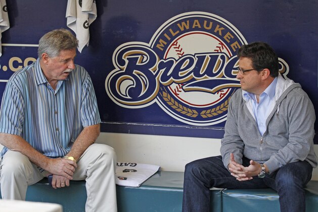 Milwaukee Brewers owner Mark Attanasio, right, talks with general manager Doug Melvin in the dugout before a baseball game between the Milwaukee Brewers and Los Angeles Dodgers Monday, Aug. 15, 2011, in Milwaukee. (AP Photo/Jeffrey Phelps)