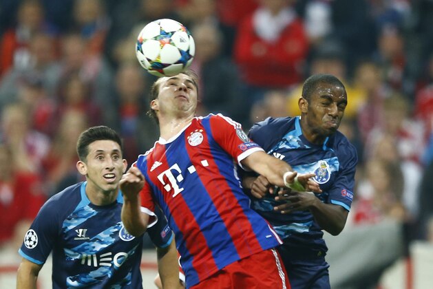 Bayern's Mario Goetze, center, is checked by Porto's Ricardo during the soccer Champions League quarterfinal second leg match between Bayern Munich and FC Porto at the Allianz Arena in Munich, southern Germany, Tuesday, April 21, 2015. (AP Photo/Matthias Schrader)