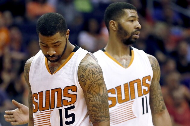 Phoenix Suns' Marcus Morris (15) and his twin brother Markieff Morris (11) take the court during a time out during the second half of an NBA basketball game against the Utah Jazz, Saturday, April 4, 2015, in Phoenix. Marcus and Markieff Morris are being investigated on allegations that they joined three other men in beating a former mentor, according to police documents made available Wednesday. (AP Photo/Matt York)