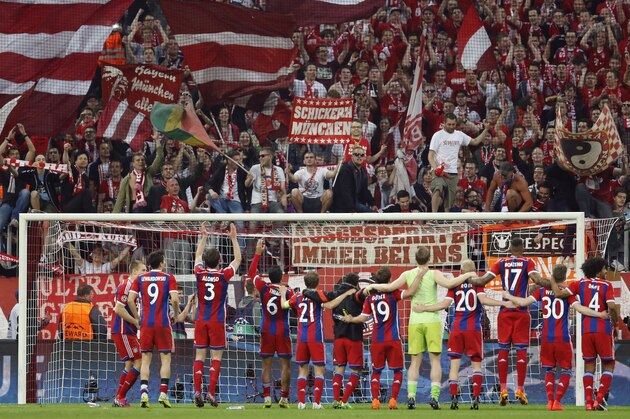 Bayern players greet their fans following the soccer Champions League quarterfinal second leg match between Bayern Munich and FC Porto at the Allianz Arena in Munich, southern Germany, Tuesday, April 21, 2015. (AP Photo/Michael Probst)