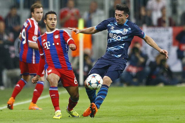 Bayern's Thiago, left, and Porto's Hector Herrera challenge for the ball during the soccer Champions League quarterfinal second leg match between Bayern Munich and FC Porto at the Allianz Arena in Munich, southern Germany, Tuesday, April 21, 2015. (AP Photo/Matthias Schrader)