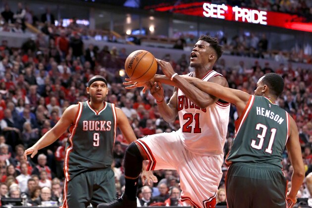 Chicago Bulls guard Jimmy Butler (21) is fouled by Milwaukee Bucks center John Henson (31) as Jared Dudley watches during the second half in Game 2 of the NBA basketball playoffs Monday, April 20, 2015, in Chicago. The Bulls won 91-82. (AP Photo/Charles Rex Arbogast)