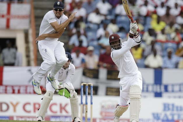 England captain Alistair Cook jumps to avoid being hit by a shot played by West Indies' Marlon Samuels, right, from a delivery of Moeen Ali during day one of their second Test match at the National Stadium in St. George's, Grenada, Tuesday, April 21, 2015. (AP Photo/Ricardo Mazalan)