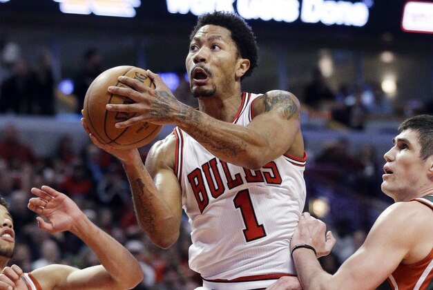 Chicago Bulls guard Derrick Rose, center, drives to the basket against Milwaukee Bucks forward Ersan Ilyasova, right, and guard Michael Carter-Williams during the second half in Game 1 of the NBA basketball playoffs Saturday, April 18, 2015, in Chicago. (AP Photo/Nam Y. Huh)