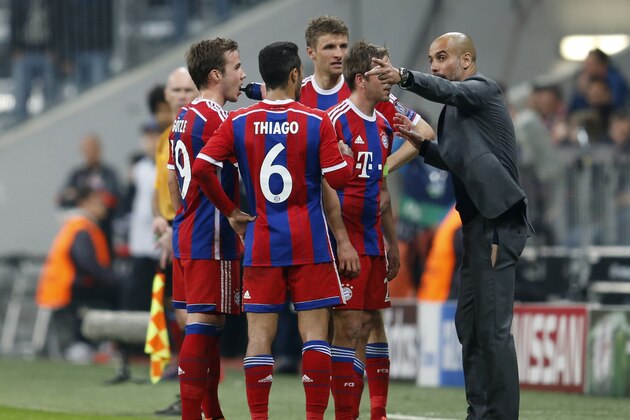Bayern's head coach Pep Guardiola, right, instructs his players during the soccer Champions League quarterfinal second leg match between Bayern Munich and FC Porto at the Allianz Arena in Munich, southern Germany, Tuesday, April 21, 2015. (AP Photo/Michael Probst)