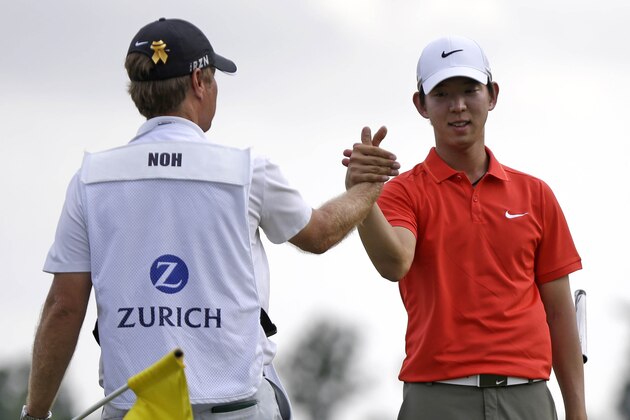 Noh Seung-yul, right, of South Korea, is congratulated by caddy Scott Sajtinac on the 18th green after winning the Zurich Classic golf tournament at TPC Louisiana in Avondale, La., Sunday, April 27, 2014. (AP Photo/Bill Haber)