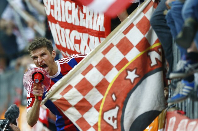 Bayern's Thomas Mueller celebrates with fans after winning 6-1 during the soccer Champions League quarterfinal second leg match between Bayern Munich and FC Porto at the Allianz Arena in Munich, southern Germany, Tuesday, April 21, 2015. (AP Photo/Matthias Schrader)