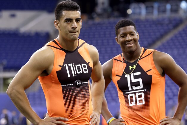 Oregon quarterback Marcus Mariota (11) and Florida State quarterback Jameis Winston (15) wait to run a drill at the NFL football scouting combine in Indianapolis, Saturday, Feb. 21, 2015. (AP Photo/David J. Phillip)