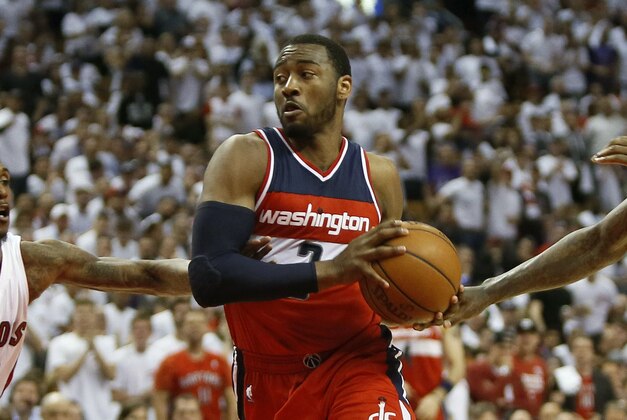 Apr 18, 2015; Toronto, Ontario, CAN; Washington Wizards guard John Wall (2) drives in between Toronto Raptors guard Louis Williams (23) and forward Amir Johnson (15)  in game one of the first round of the NBA Playoffs at Air Canada Centre. Washington defeated Toronto 93-86. Mandatory Credit: John E. Sokolowski-USA TODAY Sports