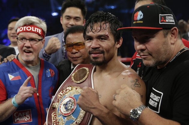 Manny Pacquiao, center, poses with trainer Freddie Roach, left, and his champion's belt after his WBO welterweight title boxing fight against Timothy Bradley Saturday, April 12, 2014, in Las Vegas. (AP Photo/Isaac Brekken)