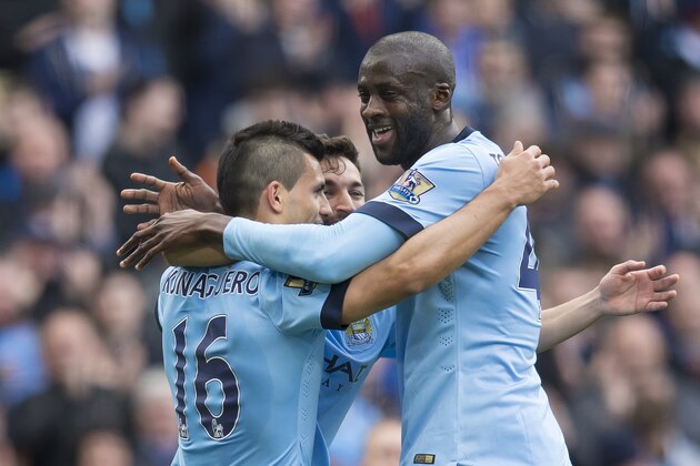 Manchester City's Sergio Aguero, left, celebrates with teammates Jesus Navas and Yaya Toure, right, after scoring against West Ham United's during the English Premier League soccer match between Manchester City and West Ham United at the Etihad Stadium, Manchester, England, Sunday April 19, 2015. (AP Photo/Jon Super)