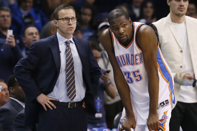 Scott Brooks, left, and forward Kevin Durant (35) talk during the fourth quarter of an NBA basketball game against the Dallas Mavericks in Oklahoma City, Thursday, Feb. 19, 2015. Oklahoma City won 104-89. (AP Photo/Sue Ogrocki)
