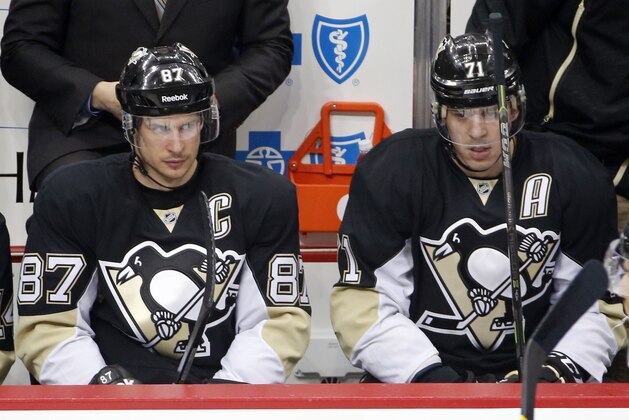 Pittsburgh Penguins' Sidney Crosby (87) and Evgeni Malkin (71) sit on the bench  during the first period of a first-round NHL playoff hockey game against the New York Rangers in Pittsburgh Monday, April 20, 2015. The Rangers won 2-1. (AP Photo/Gene J. Puskar)