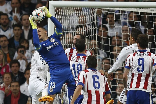 Atletico goalkeeper Jan Oblak saves during the second leg quarterfinal Champions League soccer match between Real Madrid and Atletico Madrid at Santiago Bernabeu stadium in Madrid, Spain, Wednesday April 22, 2015. (AP Photo/Paul White)