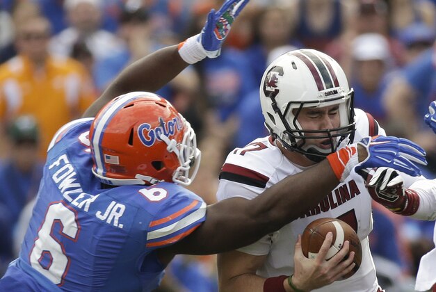 Florida's Dante Fowler, Jr. (6) sacks South Carolina quarterback Dylan Thompson during the second half of an NCAA college football game in Gainesville, Fla., Saturday, Nov. 15, 2014. South Carolina won in overtime 23-20. (AP Photo/John Raoux)