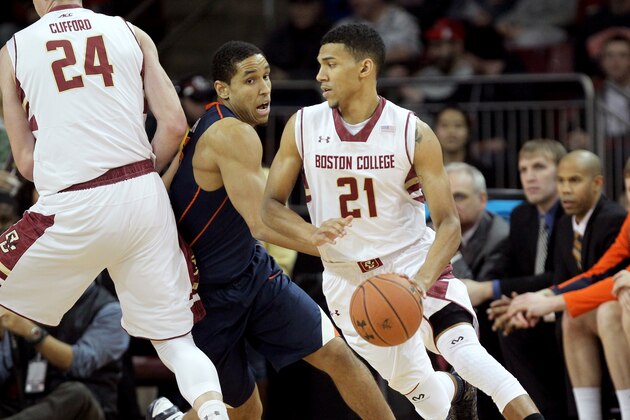 Boston College guard Olivier Hanlan (21) uses a screen from teammate Dennis Clifford as he tries to break free from Virginia guard Malcolm Brogdon (15) during the first half of an NCAA college basketball game Saturday, Jan. 17, 2015, in Boston. (AP Photo/Mary Schwalm)