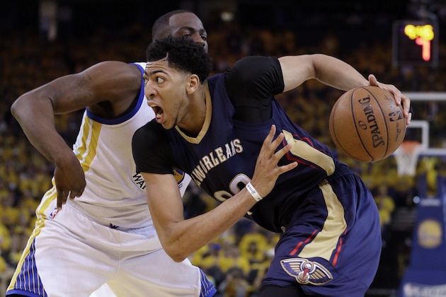 New Orleans Pelicans' Anthony Davis, right, drives past Golden State Warriors' Draymond Green during the second half in Game 1 of the NBA basketball playoffs Saturday, April 18, 2015, in Oakland, Calif. Golden State won 106-99. (AP Photo/Marcio Jose Sanchez)