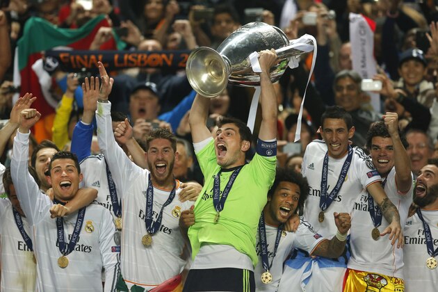 FILE - In this May 24, 2014, file photo, Real goalkeeper Iker Casillas, center, lifts the Champion League trophy, as he and teammates, celebrate winning the Champion League title, against Atletico Madrid, in Lisbon, Portugal.  (AP Photo/Andres Kudacki, File)