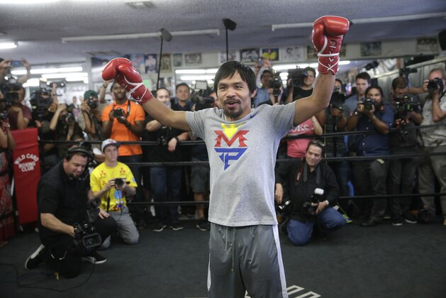 Manny Pacquiao, of the Philippines, raises his arms after his workout in front of reporters and photographers Wednesday, April 15, 2015, in Los Angeles. Pacquiao is scheduled to fight Floyd Mayweather Jr. in a welterweight boxing match in Las Vegas on May 2. (AP Photo/Jae C. Hong)