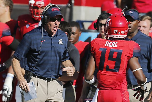 Arizona head coach Rich Rodriguez, left, talks to Davonte' Neal (19) during the first half of an NCAA college football game against Arizona State, Friday, Nov. 28, 2014, in Tucson, Ariz. (AP Photo/Rick Scuteri)