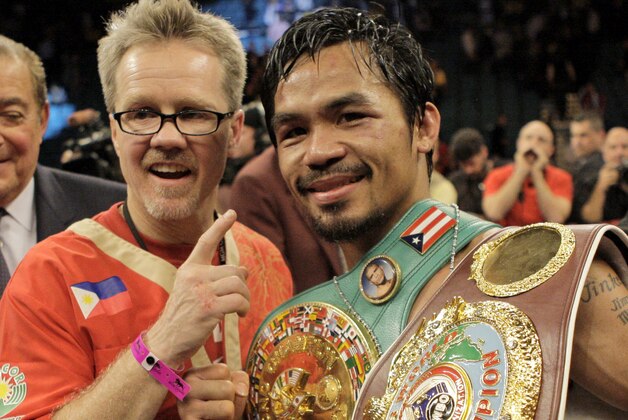 FILE - In this Nov. 14, 2009, file photo, boxer Manny Pacquiao, of the Philippines, celebrates with trainer Freddie Roach, left, at the technical knockout of Miguel Cotto in a WBO welterweight title fight in Las Vegas. Roach has guided Pacquiao to the pinnacle of boxing, yet the most celebrated trainer of his era still rises before dawn and wins his daily fight with Parkinson's disease because he always finds new reasons to live.  (AP Photo/Jae C. Hong, File)