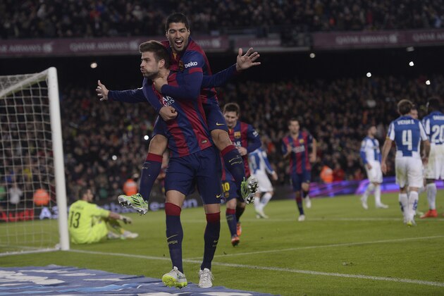 FC Barcelona's Gerard Pique, left, reacts after scoring with his teammate Luis Suarez, from Uruguay, during a Spanish La Liga soccer match against Espanyol at the Camp Nou stadium in Barcelona, Spain, Sunday, Dec. 7, 2014. (AP Photo/Manu Fernandez)