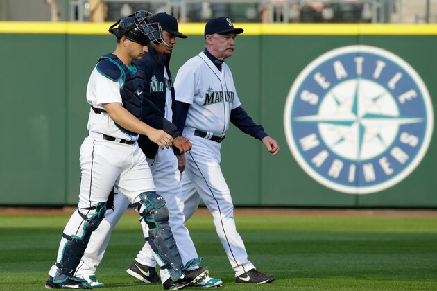 Seattle Mariners ace Felix Hernandez, center, walks with catcher Mike Zunino, left, and pitching coach Rick Waits, right, before a baseball game against the Texas Rangers, Saturday, April 18, 2015, in Seattle. (AP Photo/Ted S. Warren)