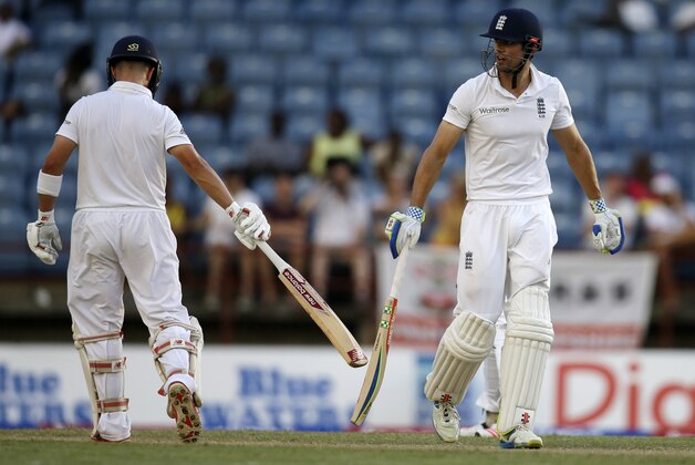 England's captain Alistair Cook, right, and teammate Jonathan Trott touch bats to celebrate runs during their partnership on day two of their second Test match against West Indies at the National Stadium in St. George's, Grenada, Wednesday, April 22, 2015. (AP Photo/Ricardo Mazalan)