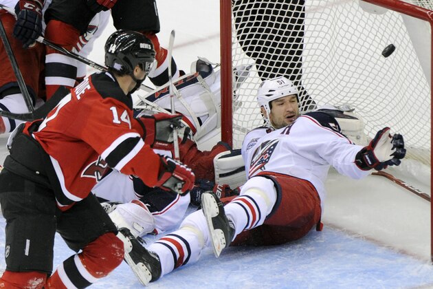 New Jersey Devils' Adam Henrique, left,  scores a goal past Columbus Blue Jackets defenseman Fedor Tyutin, of Russia, during the third period of an NHL hockey game Saturday, Nov. 1, 2014, in Newark, N.J. The Devils won 3-2.(AP Photo/Bill Kostroun)