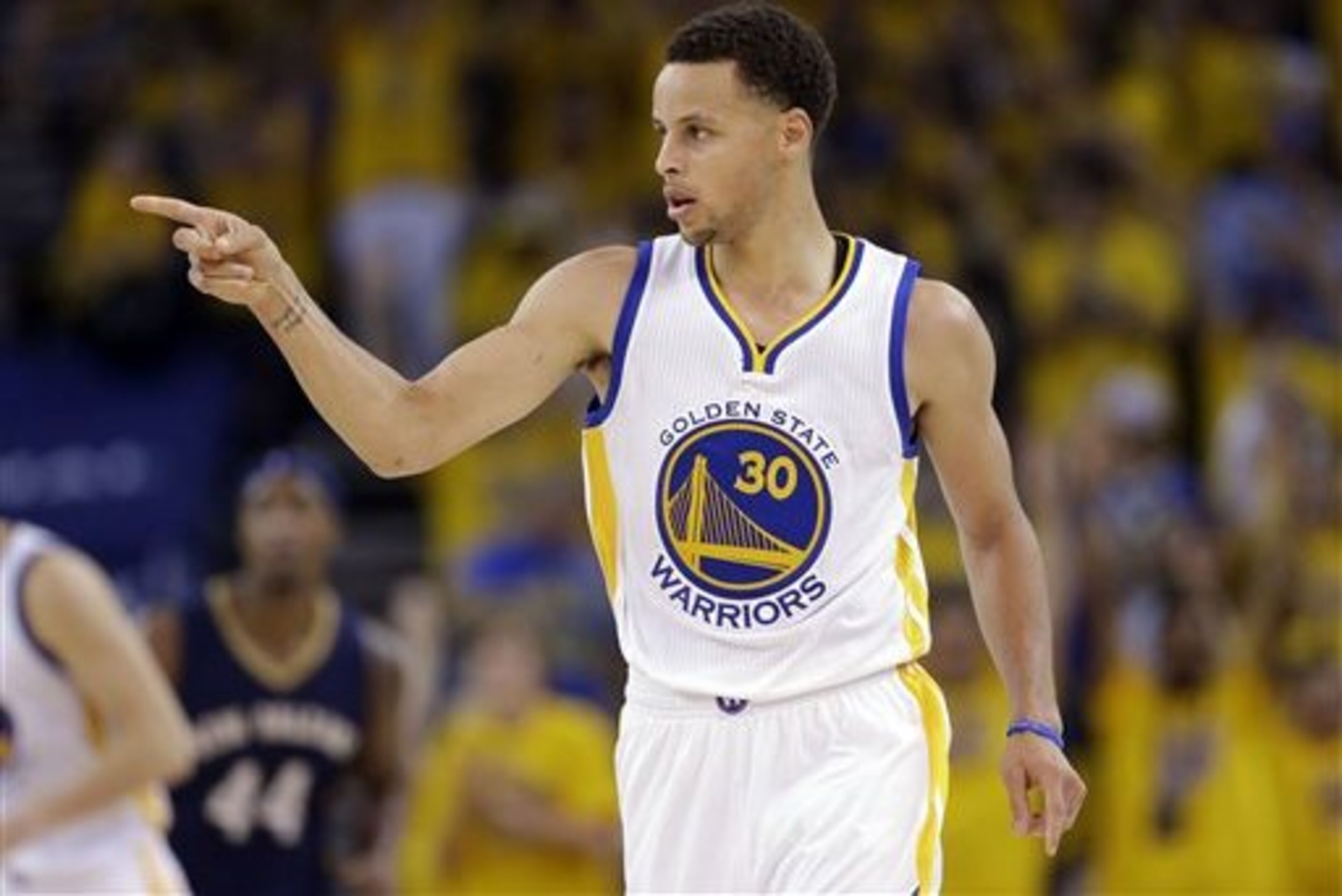 Golden State Warriors' Stephen Curry (30) points to a teammate after scoring during the second half in Game 1 of the NBA basketball playoffs against the New Orleans Pelicans Saturday, April 18, 2015, in Oakland, Calif. Golden State won 106-99. (AP Photo/Marcio Jose Sanchez)