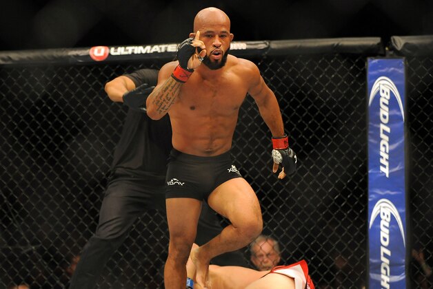 Sep 27, 2014; Las Vegas, NV, USA; Demetrious Johnson (red gloves) celebrates after referee Herb Brooks stops a featherweight title bout against Chris Cariaso (blue gloves) during UFC 178 at MGM Grand Garden Arena. Mandatory Credit: Stephen R. Sylvanie-USA TODAY Sports