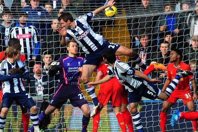 West Brom's Gareth McAuley (centre) attempts to score from a corner against Liverpool during the English Premier League soccer match between West Bromwich Albion and Liverpool at The Hawthorns stadium in West Bromwich, England, Sunday, Feb. 2, 2014.  (AP Photo/Rui Vieira)